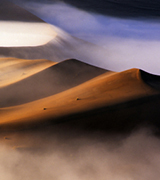 Mist flowing over Namib desert dunes.