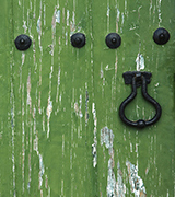 Old green wooden door with a black handle.
