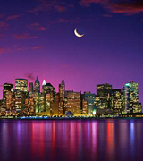 Photo of New York City at twilight with the crescent moon above.