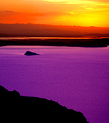 Orange sunset over a violet lake.