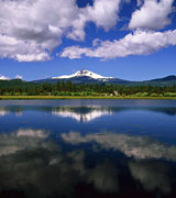 A distant snow-capped mountain reflected in a calm lake.
