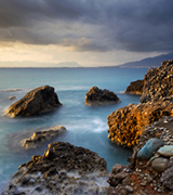 Ocean storm breaking up over a rocky shore.