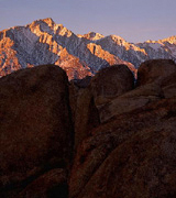 Snow-capped mountains in the distance, dark rocks in the foreground.